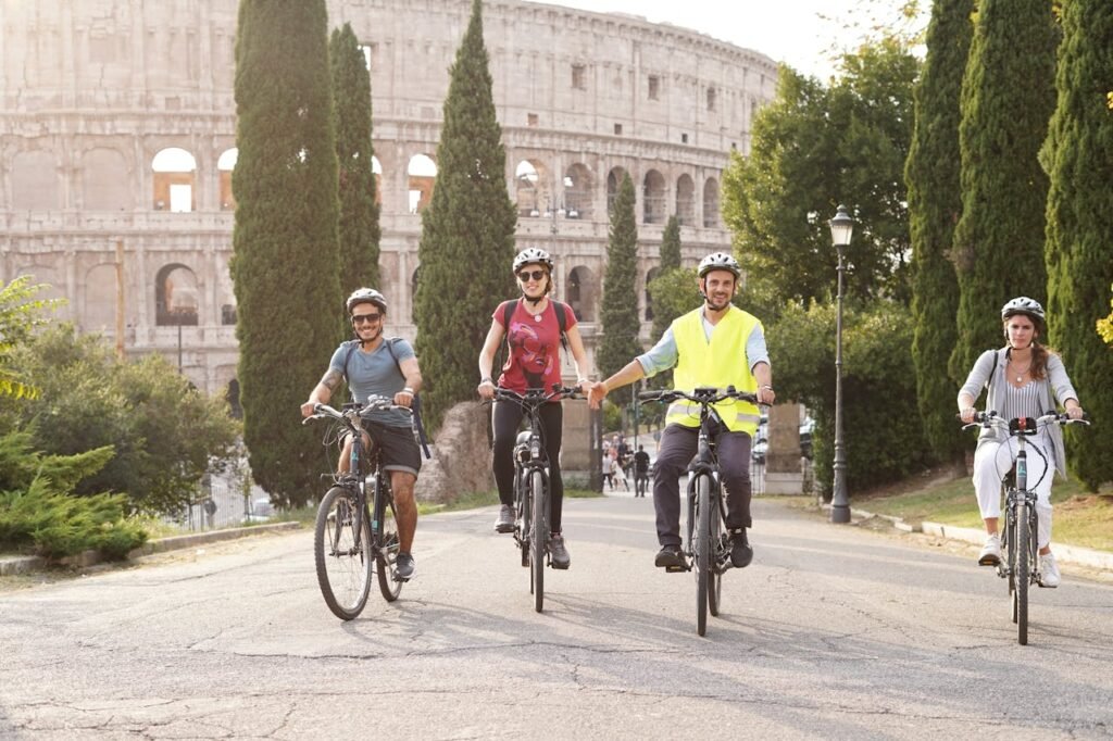 A Group of People Riding on Bicycles in front of the Colosseum in Rome, Italy 